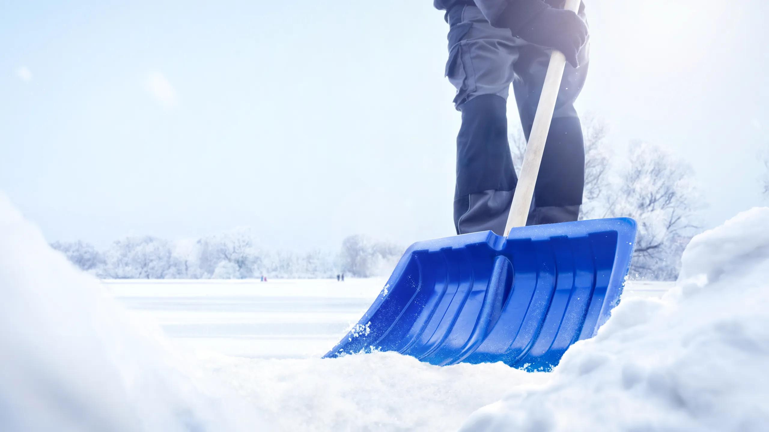 close up of a shovel being pushed through snow, bottom-up perspective.