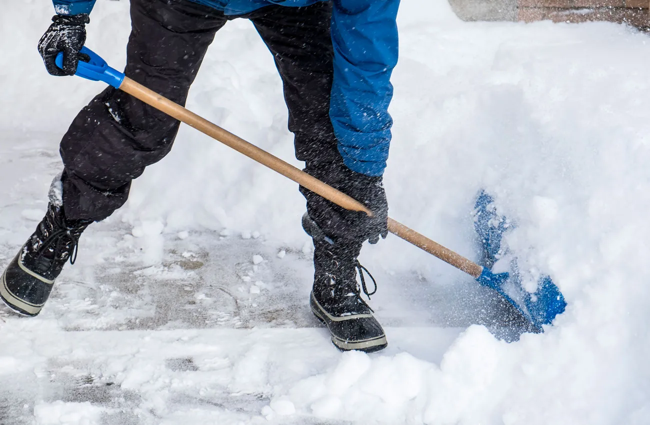 A man running a shovel through the snow.  